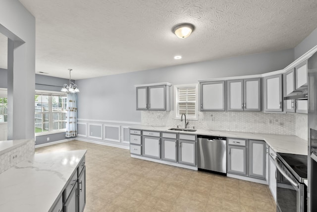 533 Lanarkshire Pl, Lexington, KY 40509 - kitchen with appliances with stainless steel finishes, gray cabinetry, a sink, a chandelier, and light stone counters