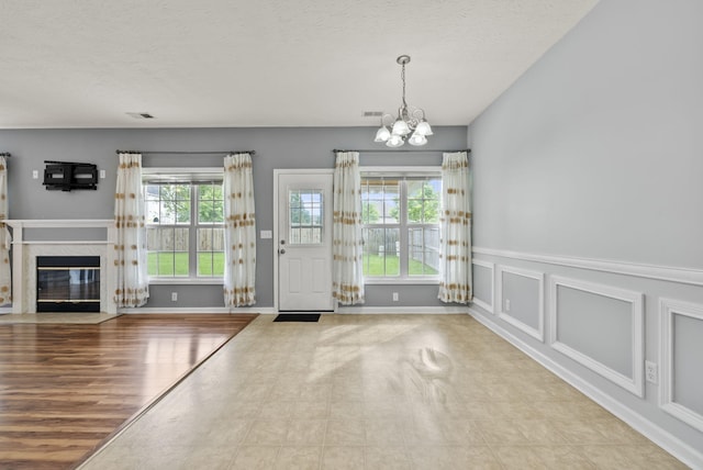 533 Lanarkshire Pl, Lexington, KY 40509 - entrance foyer with a chandelier, a fireplace with flush hearth, baseboards, and a textured ceiling