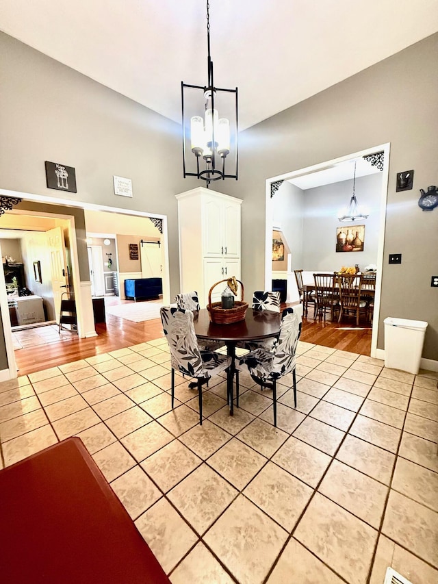 88 Powell Rd, Mckee, KY 40447 - dining area with light tile patterned floors, a chandelier, a towering ceiling, and baseboards