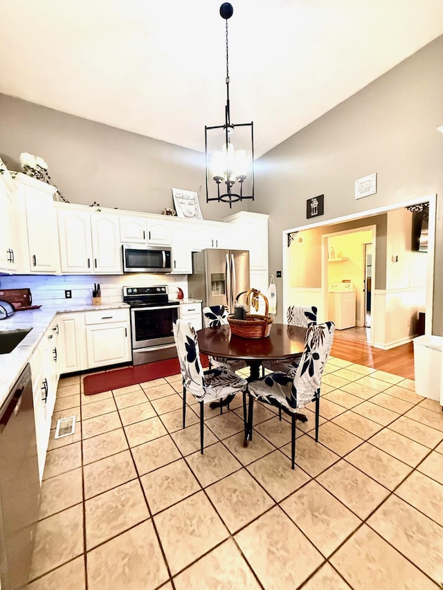 88 Powell Rd, Mckee, KY 40447 - dining room featuring light tile patterned flooring, a chandelier, and washing machine and clothes dryer