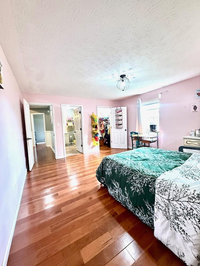 88 Powell Rd, Mckee, KY 40447 - bedroom featuring hardwood / wood-style floors, a textured ceiling, a walk in closet, baseboards, and a closet