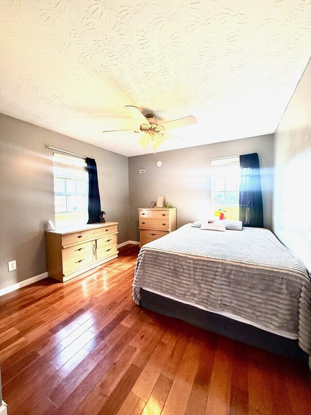 88 Powell Rd, Mckee, KY 40447 - bedroom with multiple windows, hardwood / wood-style floors, a textured ceiling, a ceiling fan, and baseboards