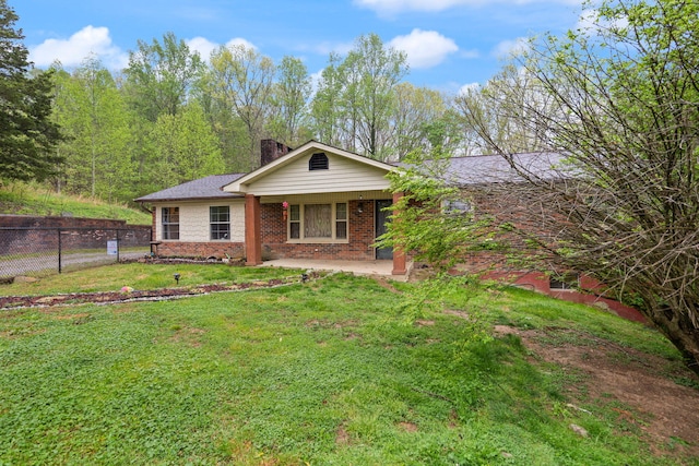 ranch-style home featuring fence, a chimney, brick siding, and a front yard