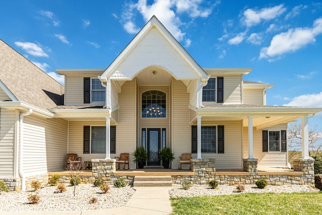 view of front of home with a shingled roof and covered porch