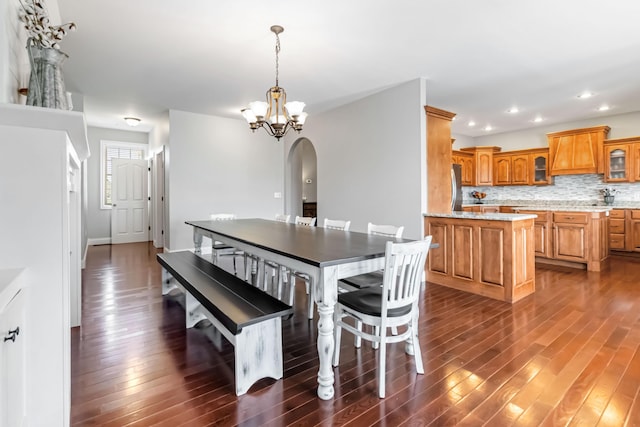 dining area with arched walkways, a chandelier, dark wood-style floors, and recessed lighting
