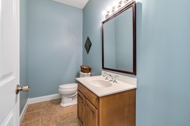 half bath featuring baseboards, toilet, vanity, and tile patterned floors