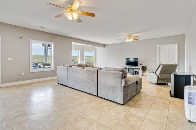 living area with ceiling fan, baseboards, light tile patterned flooring, and visible vents