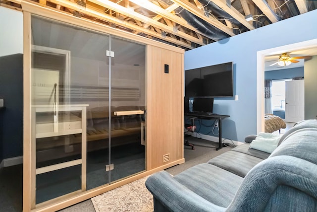living room with carpet, a ceiling fan, and a sauna