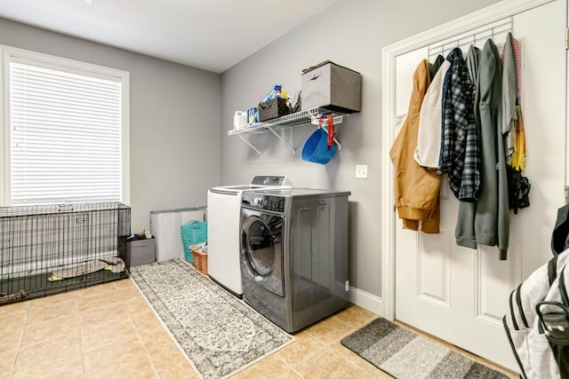 washroom featuring baseboards, tile patterned floors, separate washer and dryer, and laundry area