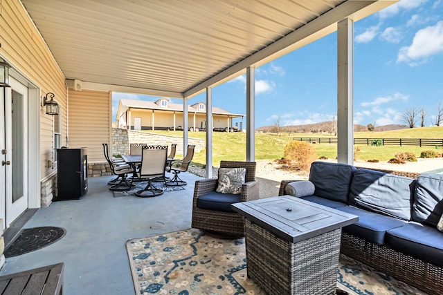 sunroom with an outdoor hangout area, a rural view, and outdoor dining space
