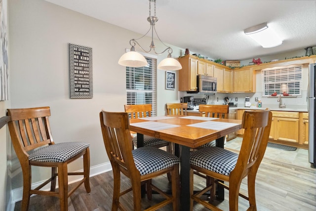 dining room featuring light wood-style flooring and baseboards