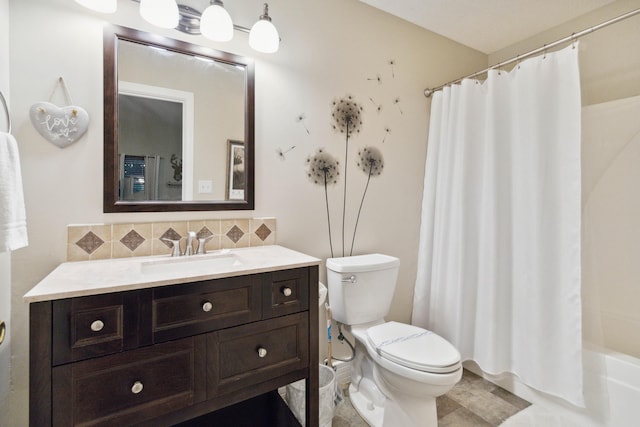 bathroom with toilet, vanity, and decorative backsplash