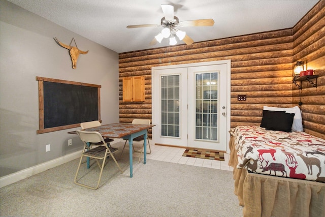 carpeted dining space featuring baseboards, a textured ceiling, rustic walls, and ceiling fan