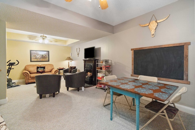 dining room featuring carpet floors, a textured ceiling, baseboards, and ceiling fan