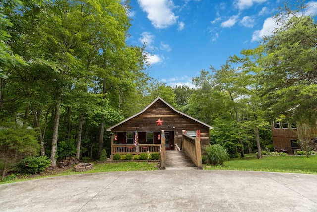 rustic home with a porch and a front yard