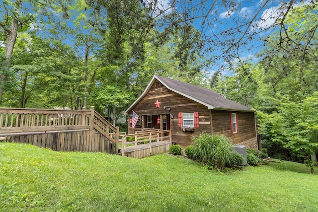view of front facade featuring a wooden deck, a front lawn, and central AC unit