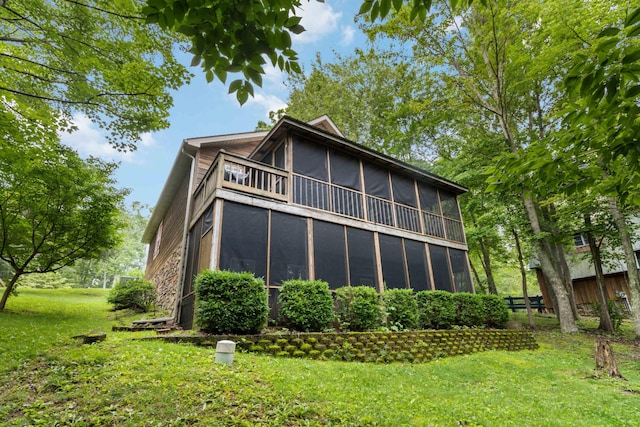 rear view of property featuring a lawn, a sunroom, and fence