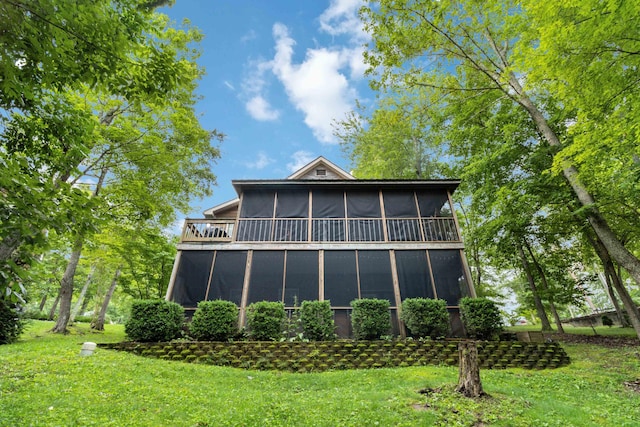 rear view of property featuring a lawn and a sunroom