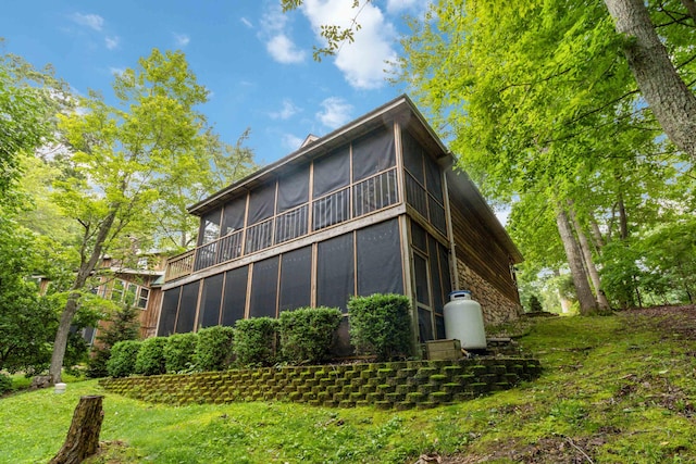 rear view of house featuring a sunroom and stone siding