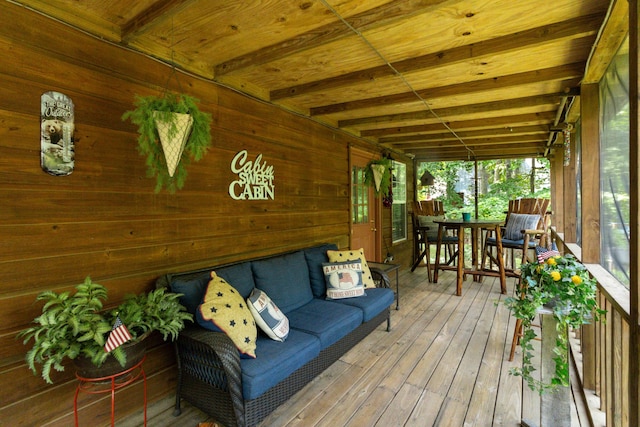 sunroom featuring outdoor dining space and beamed ceiling
