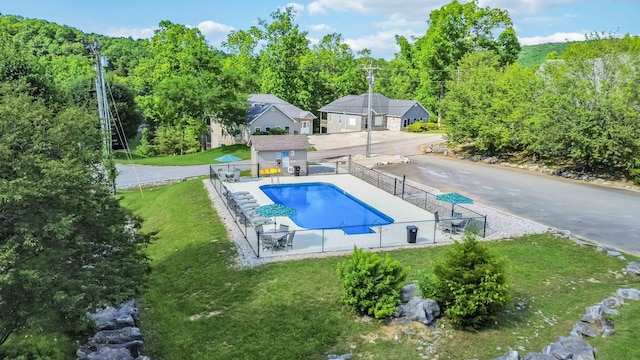 view of swimming pool featuring fence, a yard, and a fenced in pool
