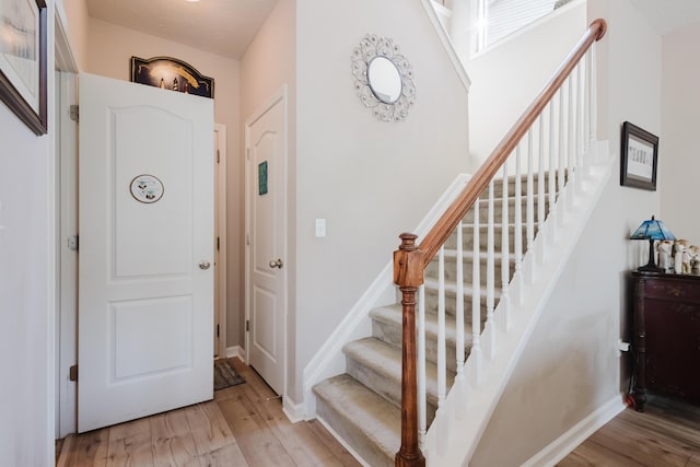 stairs with baseboards and wood finished floors