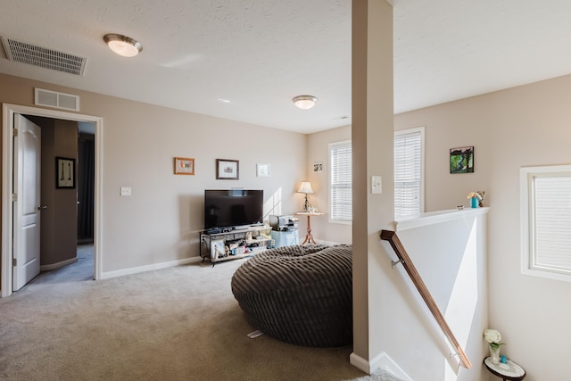 carpeted living area featuring baseboards and visible vents