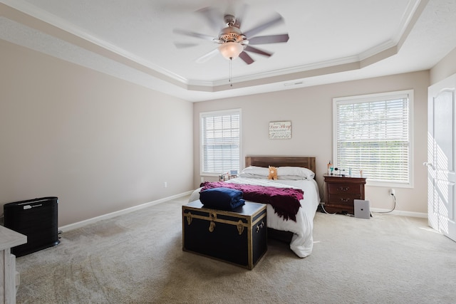 bedroom with carpet flooring, ornamental molding, and a raised ceiling