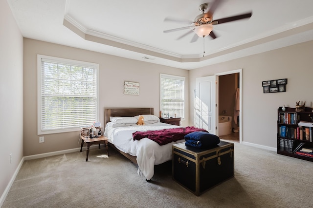 bedroom with crown molding, multiple windows, and a tray ceiling