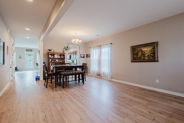 dining space with light wood-style floors, baseboards, and a notable chandelier