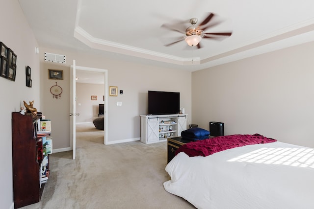 bedroom featuring carpet floors, a ceiling fan, baseboards, a tray ceiling, and ornamental molding