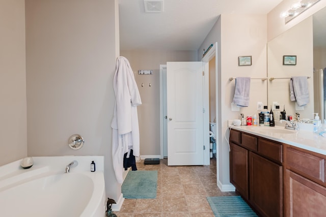 full bath with vanity, baseboards, a garden tub, and visible vents