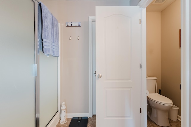 bathroom featuring visible vents, tile patterned flooring, a shower with shower door, baseboards, and toilet