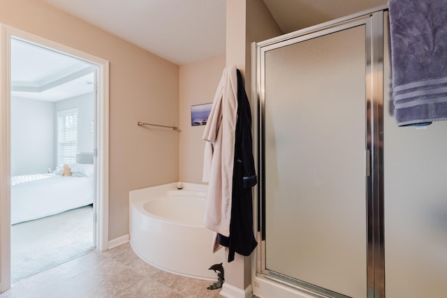 bathroom with baseboards, ensuite bathroom, a stall shower, and a bath