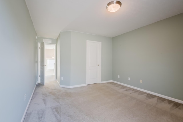 unfurnished bedroom with light colored carpet and baseboards