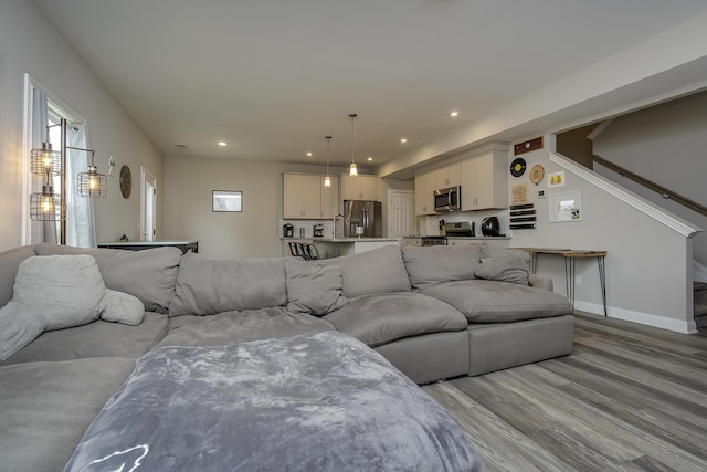 living room featuring light wood-style flooring, baseboards, and recessed lighting