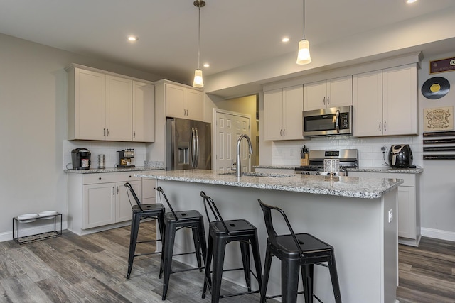 kitchen featuring tasteful backsplash, a sink, appliances with stainless steel finishes, dark wood-style flooring, and recessed lighting