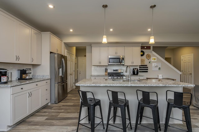 kitchen featuring backsplash, dark wood finished floors, stainless steel appliances, and a sink