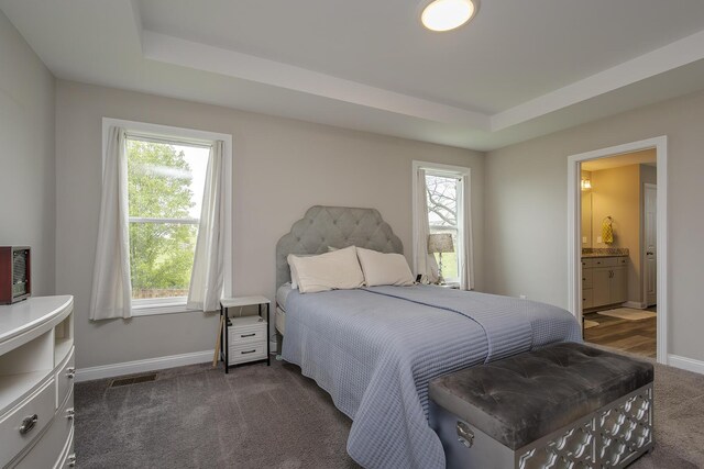 bedroom with baseboards, dark colored carpet, and multiple windows