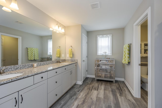 full bath featuring visible vents, wood finished floors, baseboards, and a sink
