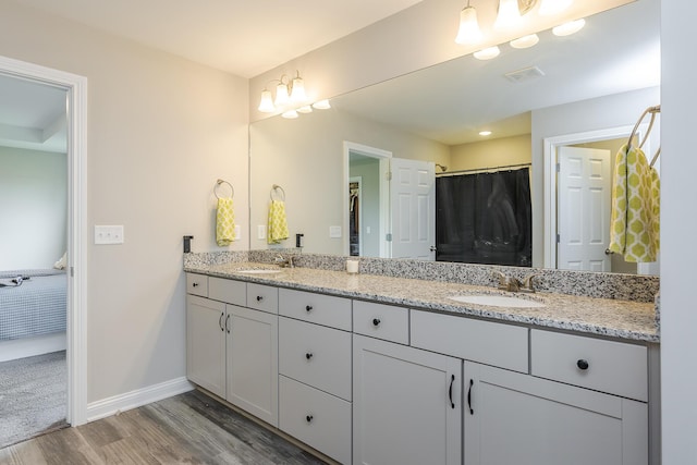 full bathroom featuring wood finished floors, visible vents, baseboards, and a sink