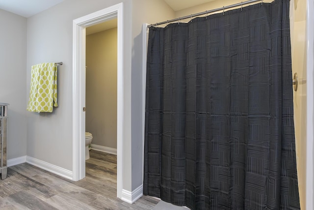 full bathroom featuring wood finished floors, toilet, baseboards, and a shower with curtain