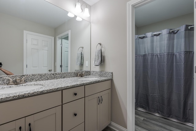 full bathroom with a shower with shower curtain, double vanity, and a sink