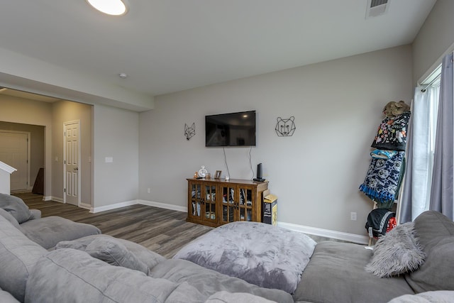 living room featuring baseboards, wood finished floors, and visible vents