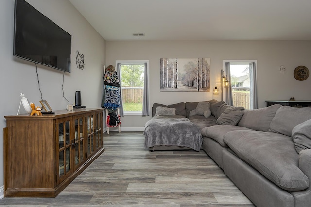 living room with baseboards, wood finished floors, and visible vents