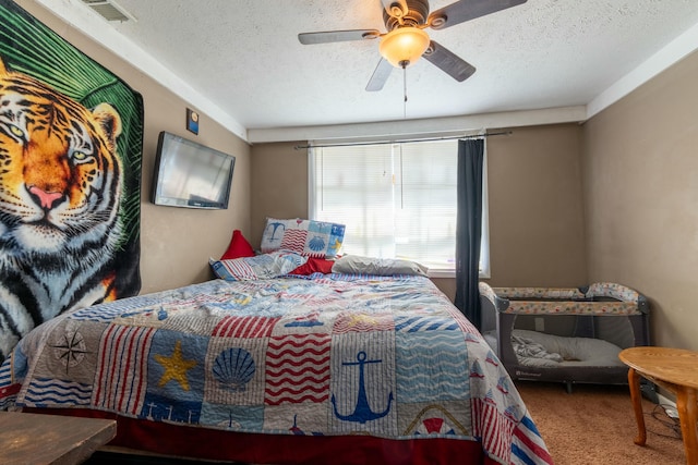 carpeted bedroom featuring a ceiling fan, a textured ceiling, and visible vents