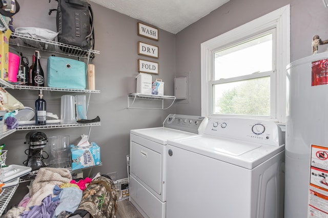 washroom with gas water heater, laundry area, wood finished floors, and washer and clothes dryer