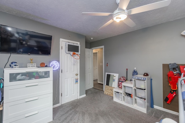 playroom with a textured ceiling, ceiling fan, baseboards, and carpet