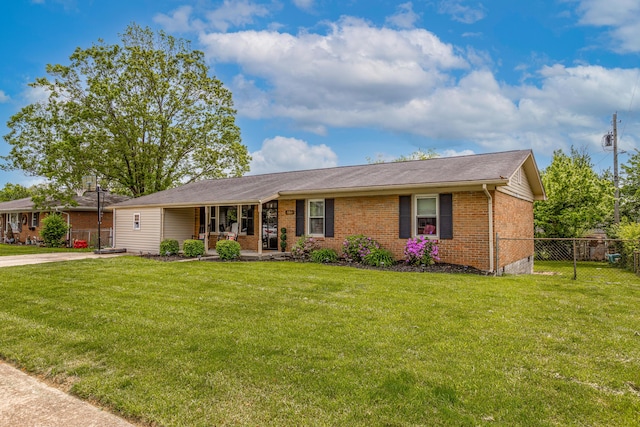 ranch-style house with covered porch, brick siding, fence, and a front lawn