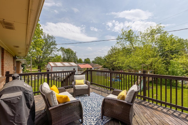 deck with an outdoor living space, a storage unit, an outbuilding, and a yard